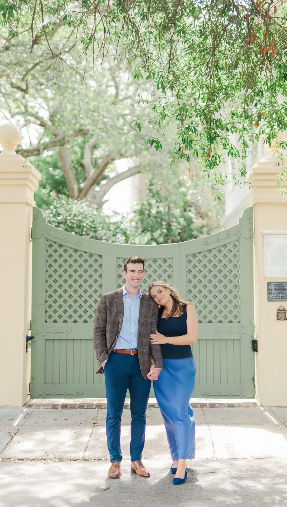 Madeleine and Lance standing together in front of a green garden gate